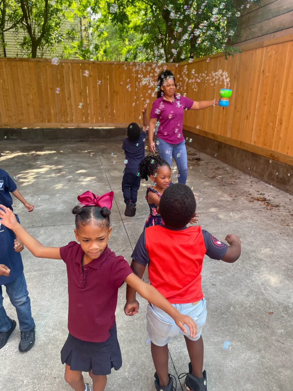 A group of children playing with bubbles in the yard.