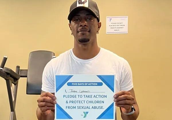A man holding up a sign that says please to take action and protect children from sexual abuse.